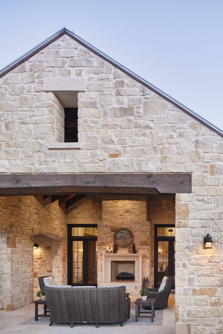 an outdoor living area with stone walls and furniture