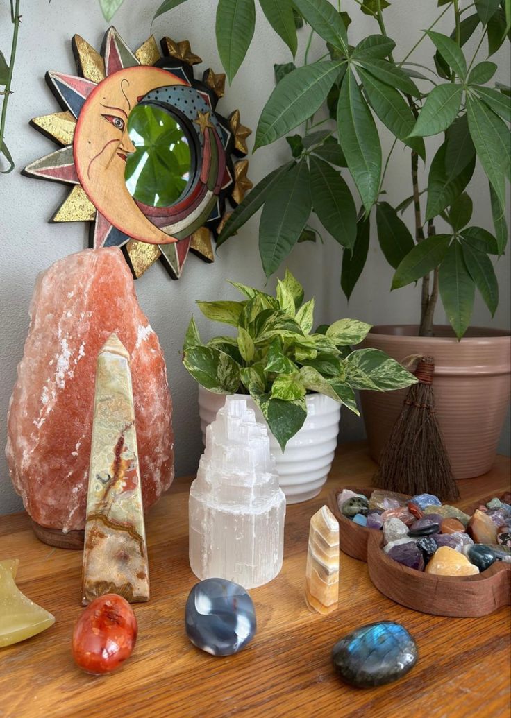 various rocks and plants on a table with a sun decoration above it, along with other items