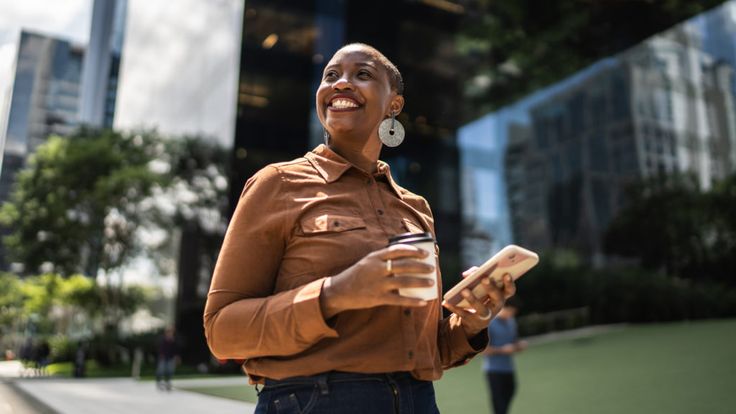 a woman standing in front of some tall buildings