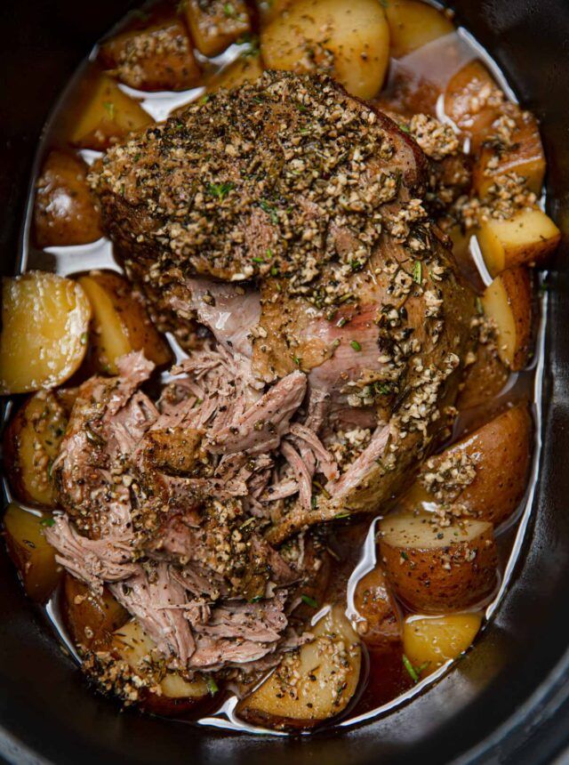 a slow cooker filled with meat and potatoes