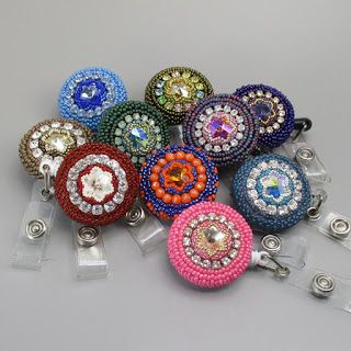 several colorful beaded round key chains are on display in front of a gray background