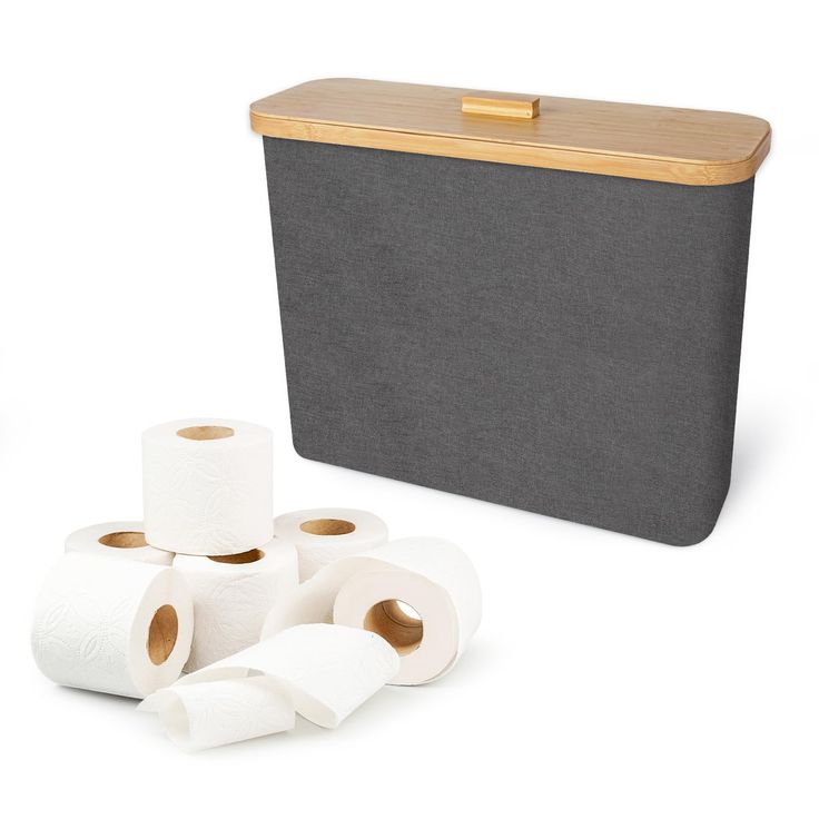 several rolls of toilet paper sitting next to a black box with bamboo lid and handles