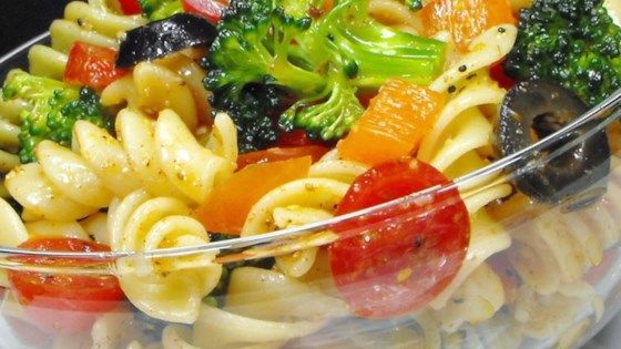 a glass bowl filled with pasta and vegetables