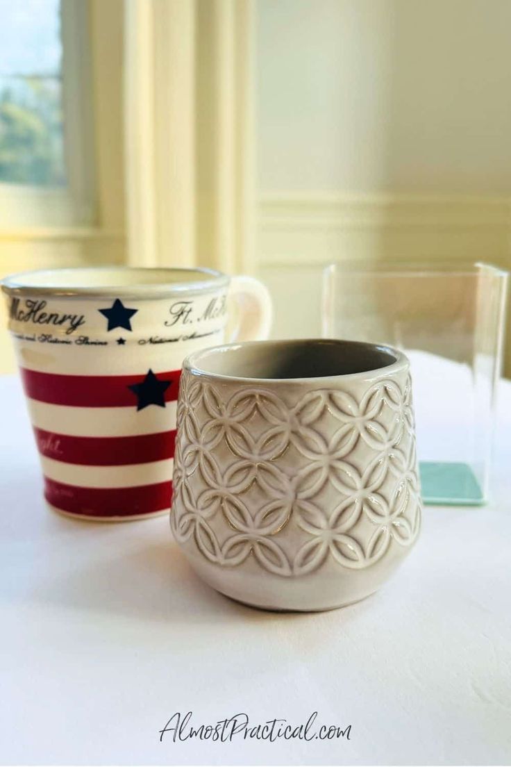 two cups sitting on top of a table next to each other with stars and stripes painted on them