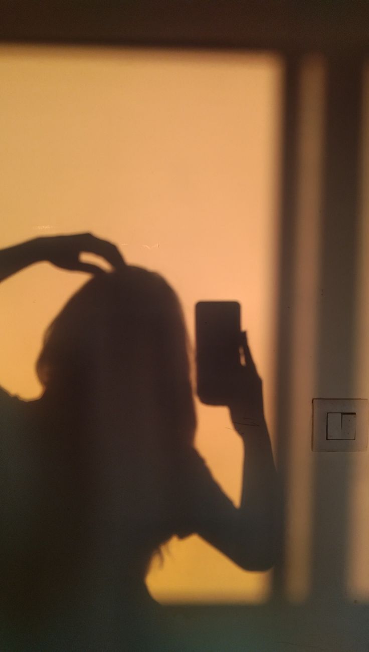 a woman taking a selfie in front of a mirror