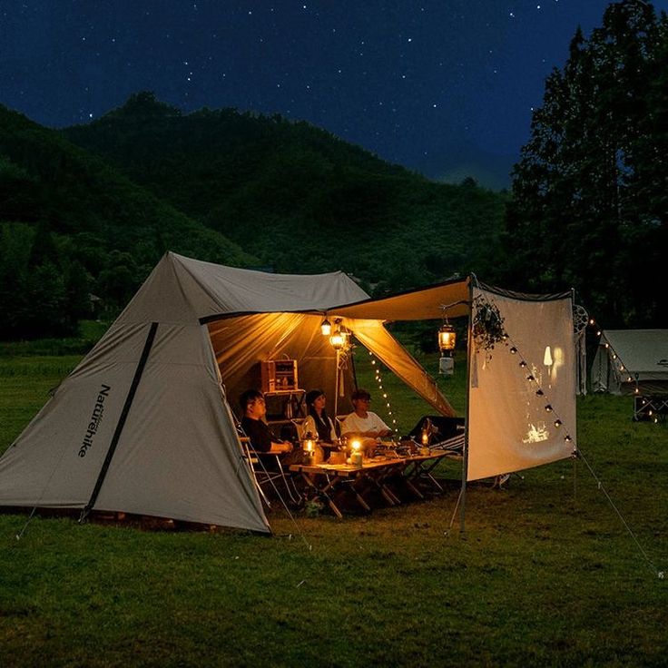 a tent set up in the middle of a field at night