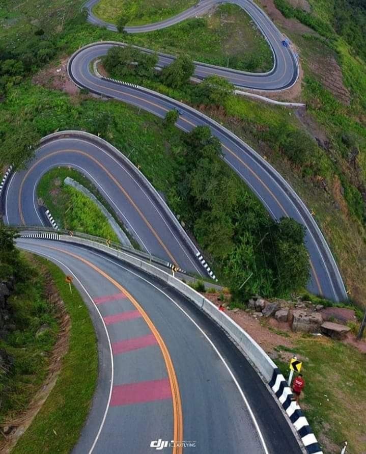 an aerial view of a winding road in the mountains