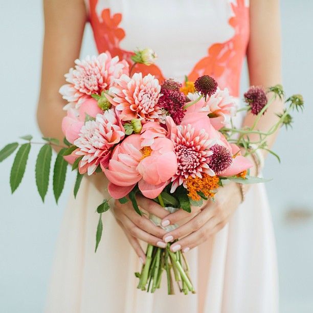 a woman holding a bouquet of flowers in her hands