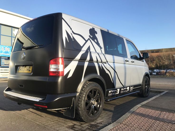 a black and white van parked in front of a building