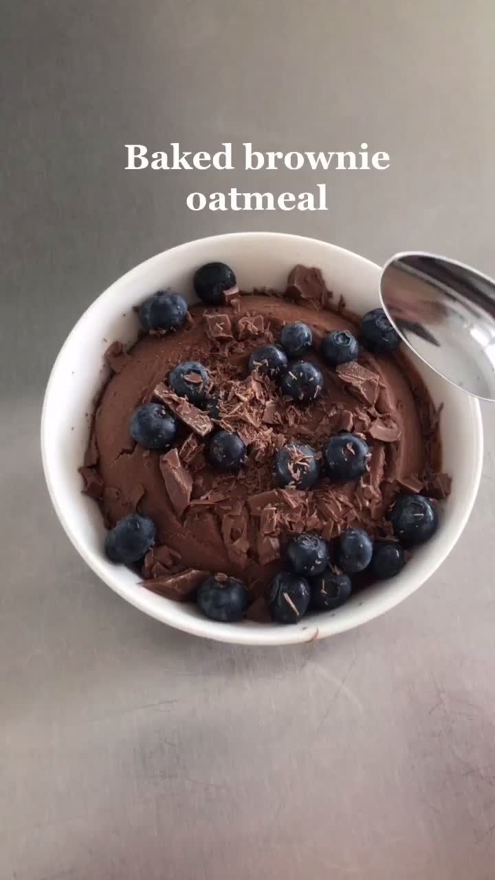 a bowl filled with chocolate and blueberries next to a spoon