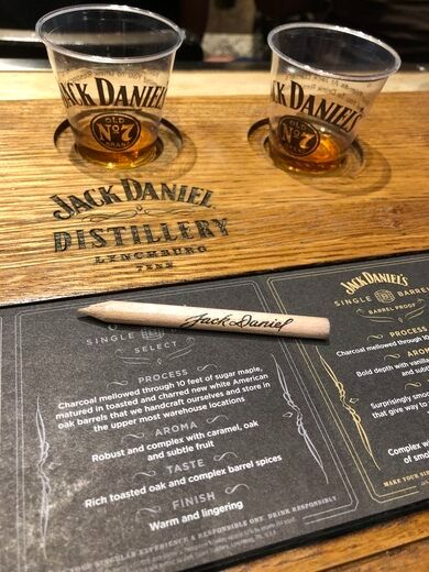 three shot glasses on top of a wooden table next to a chalk board with writing