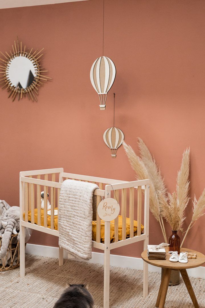 a baby's room with pink walls and white furniture