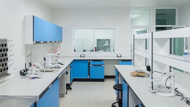 an empty laboratory with blue cabinets and white counter tops