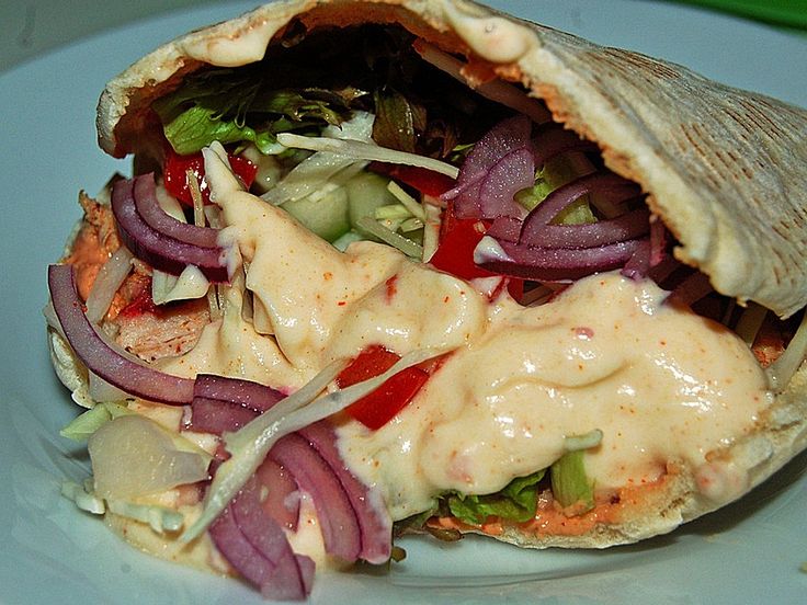 a wrap filled with meat and vegetables on a plate