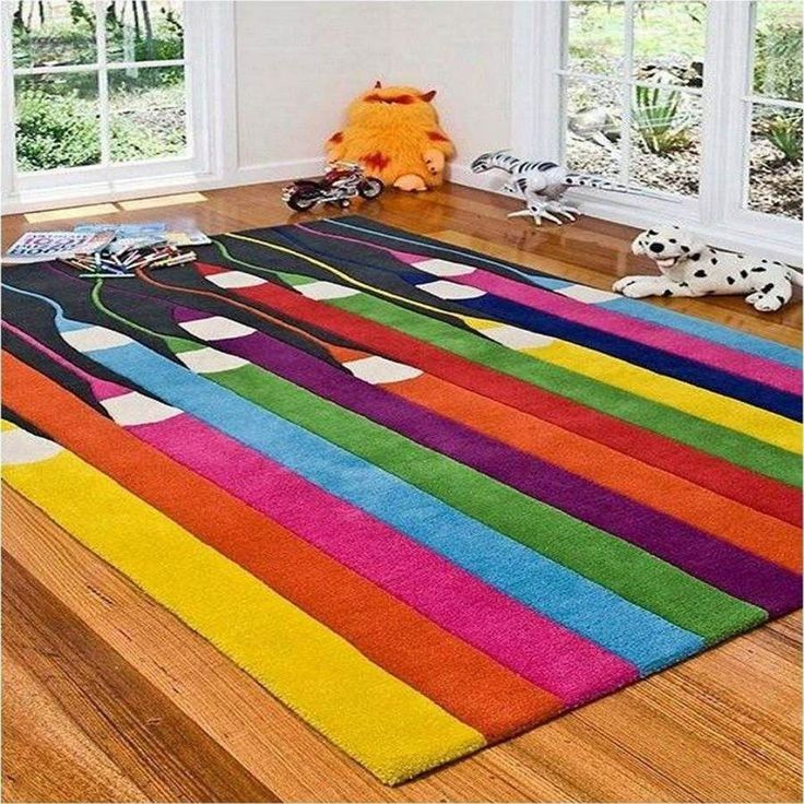 a brightly colored area rug in the middle of a room with toys on the floor