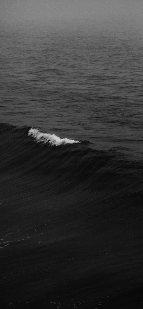 a person riding a surfboard on top of a wave in the middle of the ocean