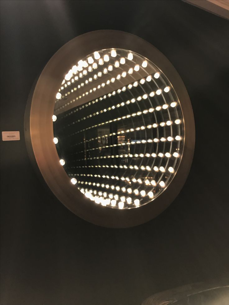 a round mirror with lights in the middle