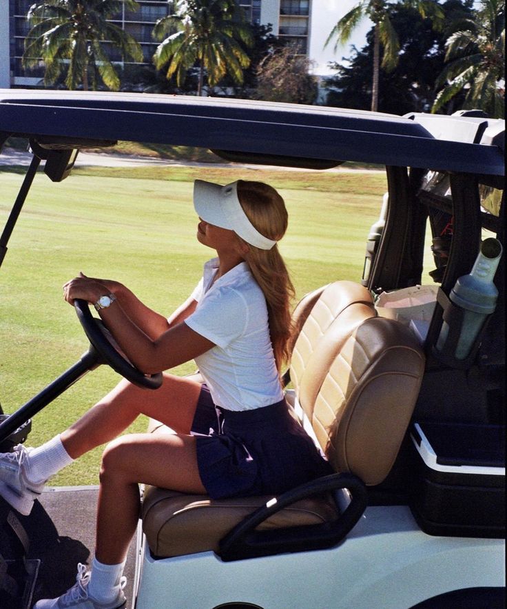 a woman sitting in the drivers seat of a golf cart