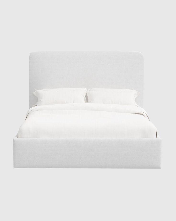 a bed with white linens and pillows on it's headboard, in front of a gray background