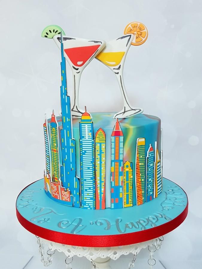 a colorful cake with two martini glasses on top