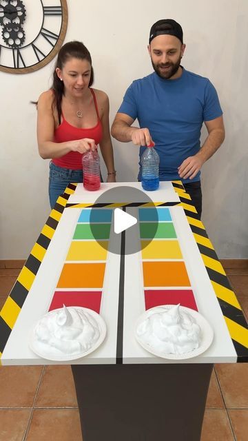 a man and woman standing in front of a table that has a game on it