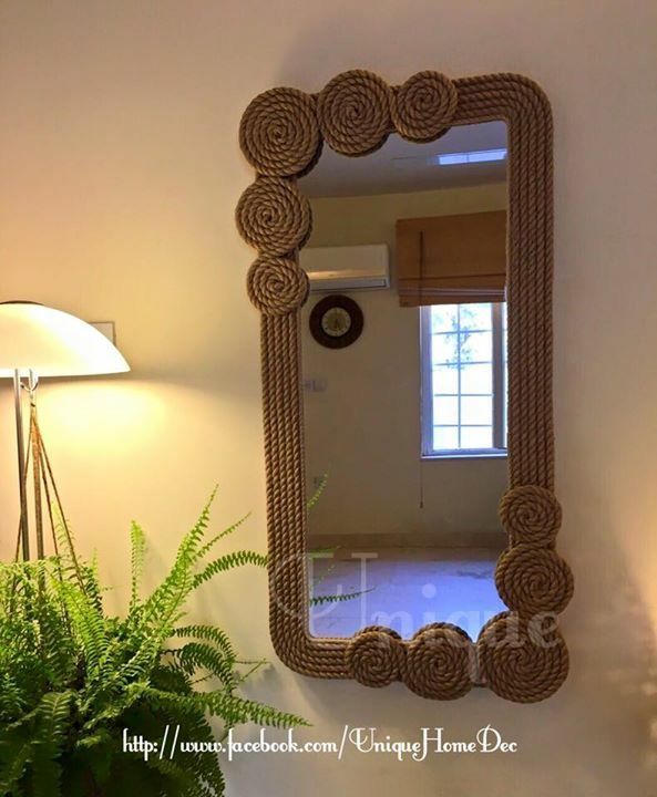 a mirror that is on the wall near a potted plant