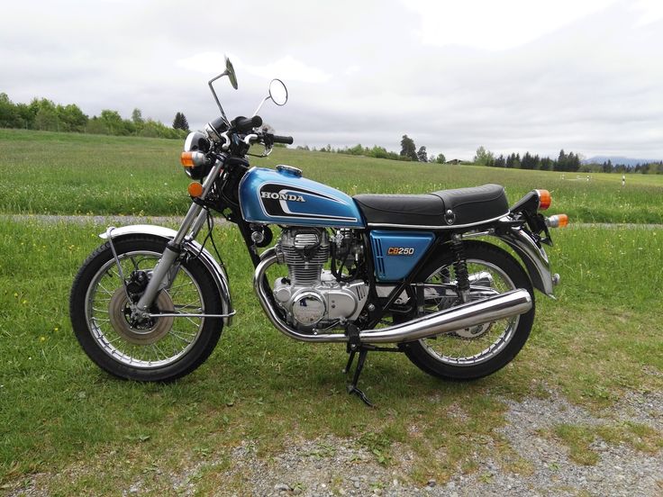 a blue motorcycle parked on top of a lush green field