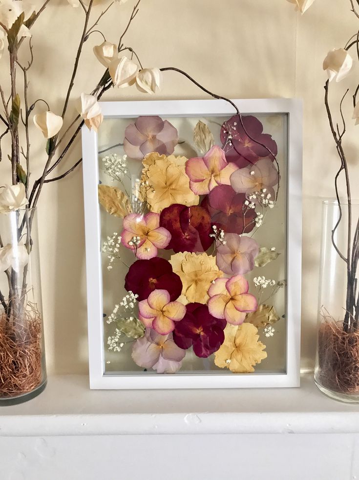 three vases filled with flowers sitting on top of a white mantle next to each other