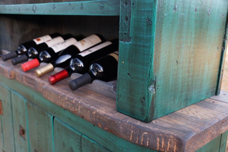 an old wooden cabinet with wine bottles in it