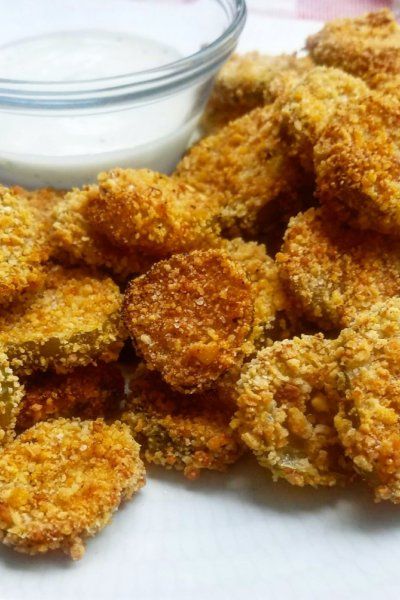 some fried food on a white plate next to a small bowl of ranch dip sauce