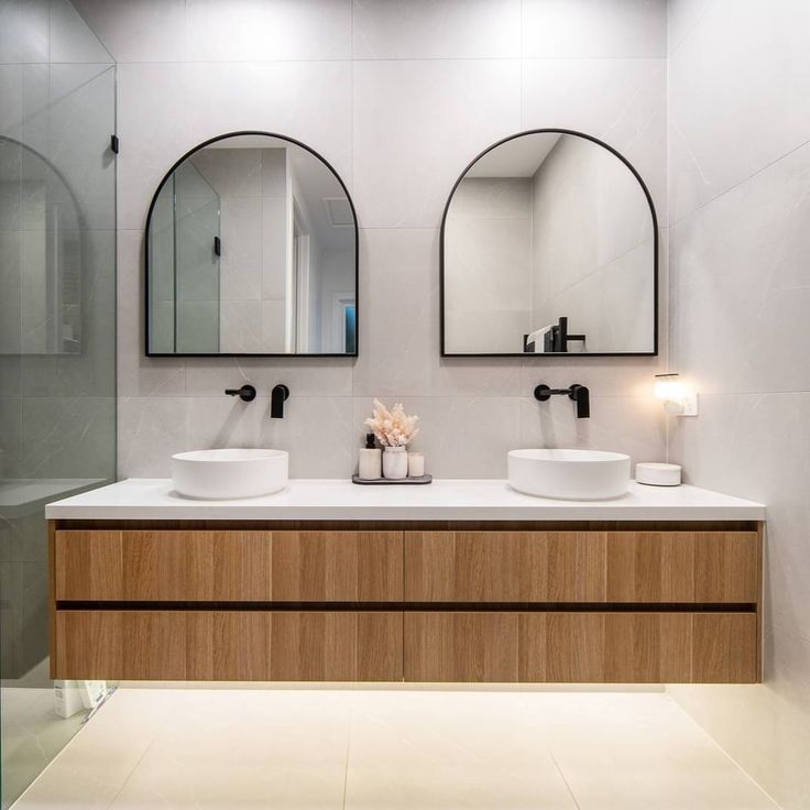 a bathroom with two sinks and mirrors on the wall