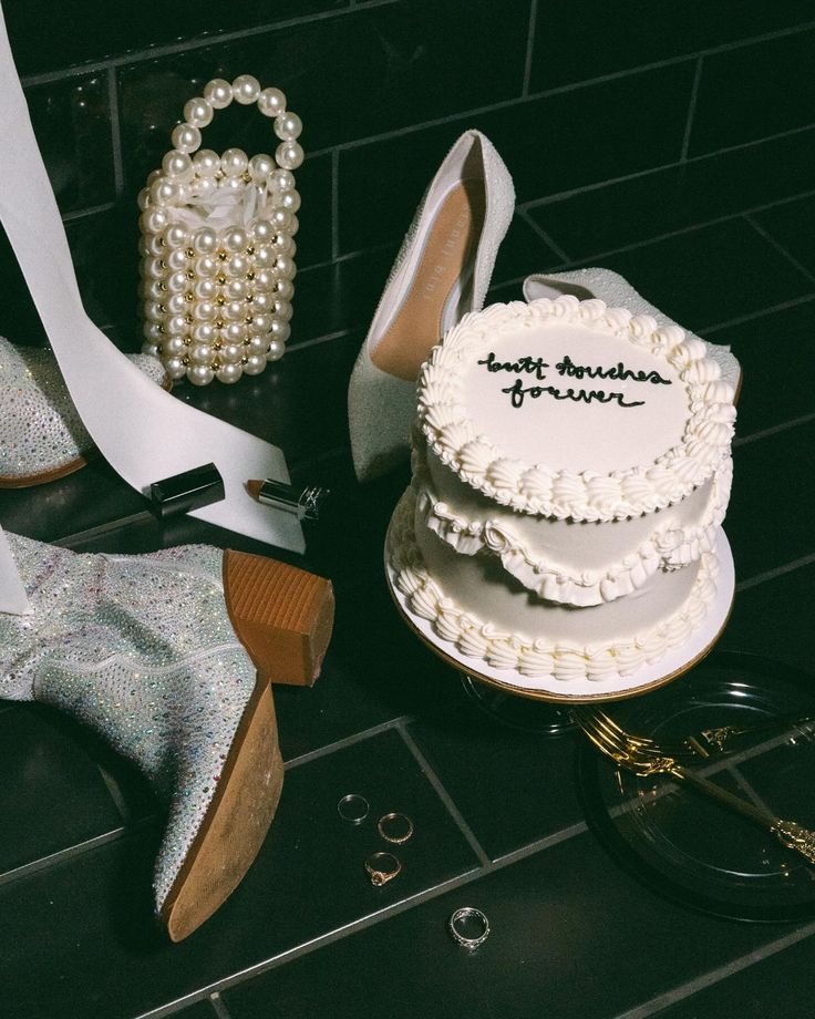 wedding cake and shoes sitting on the floor next to each other with words written on them