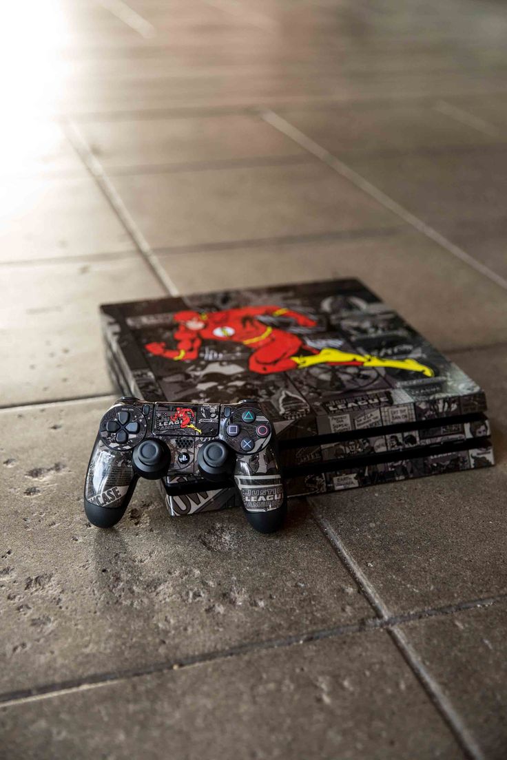 two video game controllers sitting on top of each other in front of a tile floor