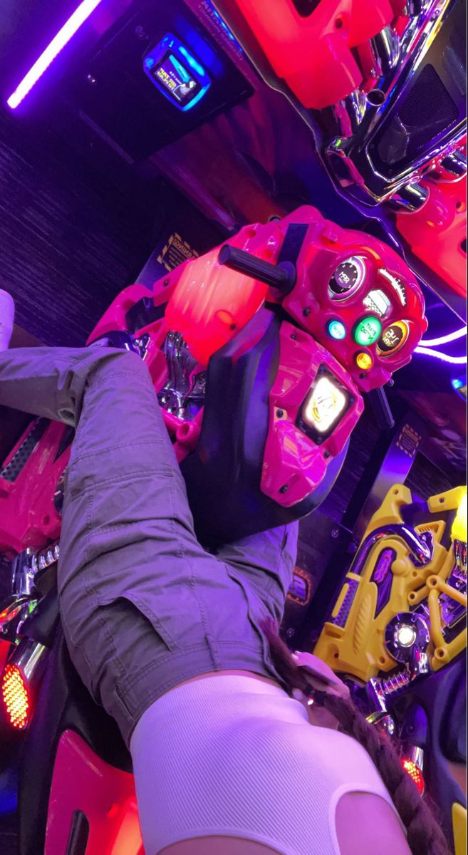 a person is laying down in a room full of neon lights and electronic gadgets