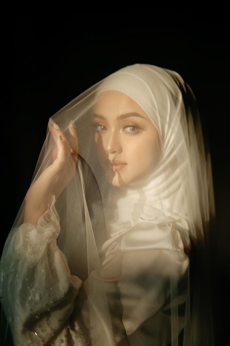 a mannequin wearing a white veil and holding her hand up to her face