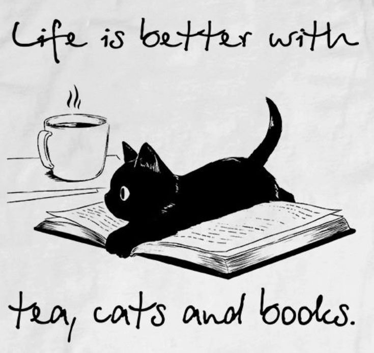 a black cat laying on top of an open book next to a cup of coffee