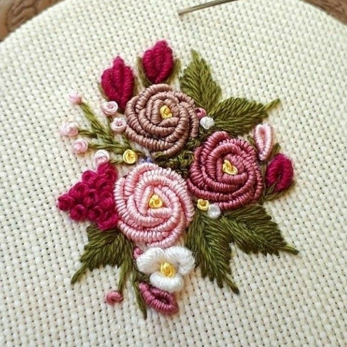 a close up of a piece of cloth with flowers on it and a needle in the middle