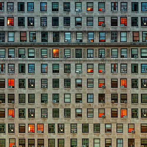 an apartment building with many windows lit up at night