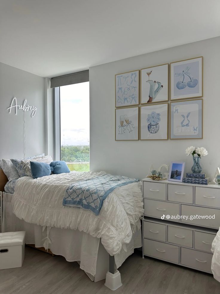 a bedroom with white furniture and pictures on the wall