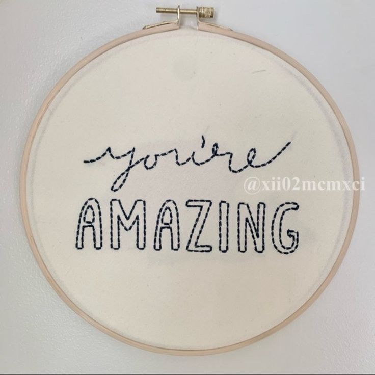 a hand embroidered wall hanging with the words you're amazing in cursive writing