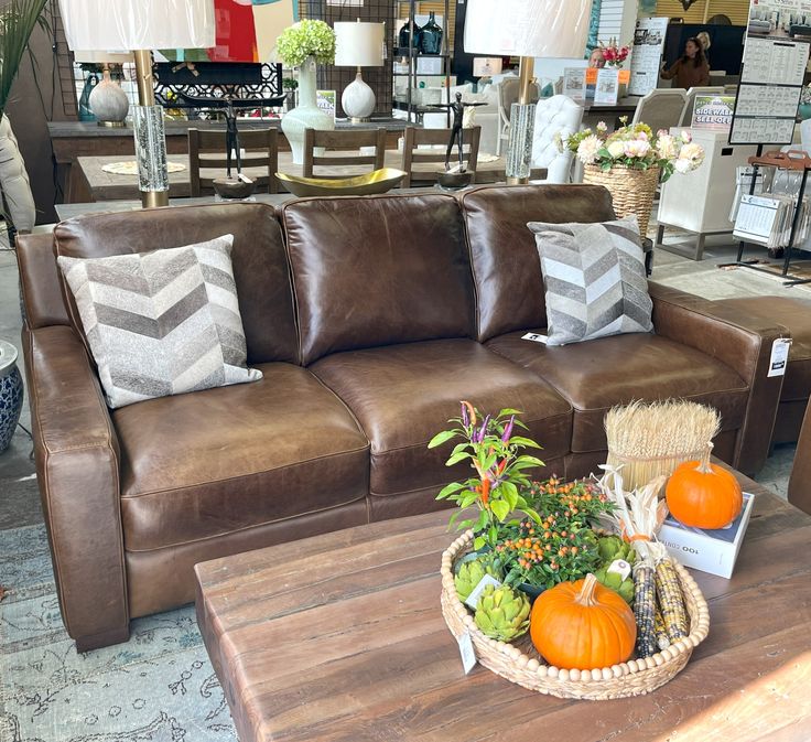 a living room filled with furniture and lots of pillows on top of a wooden table