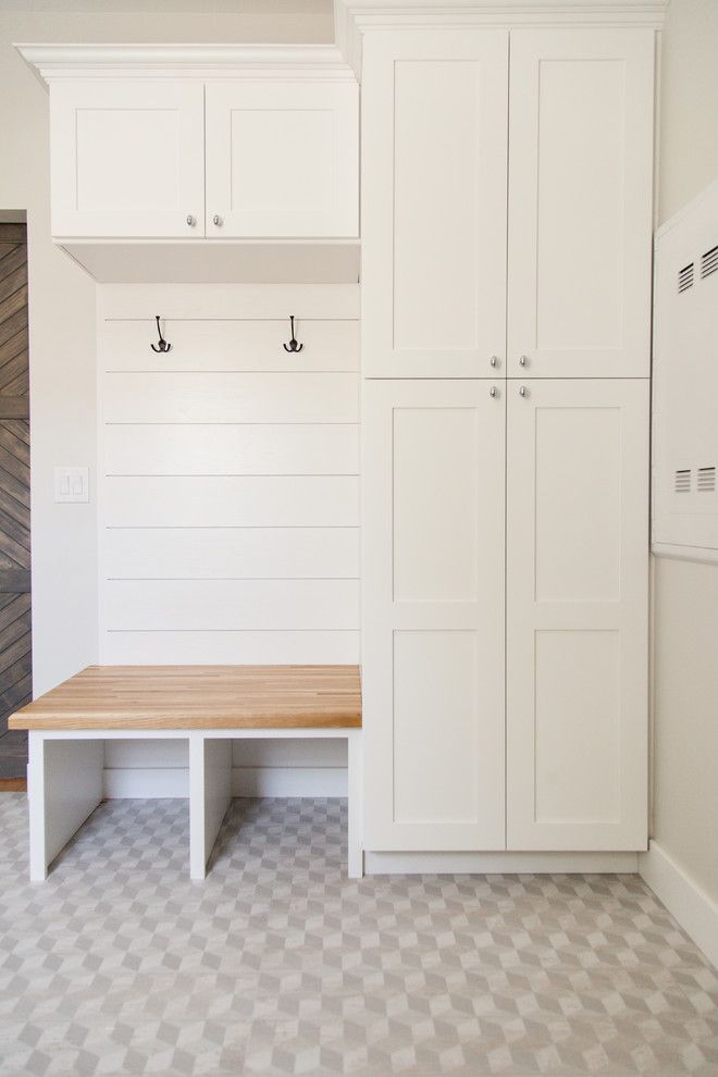 an empty room with white cabinets and bench