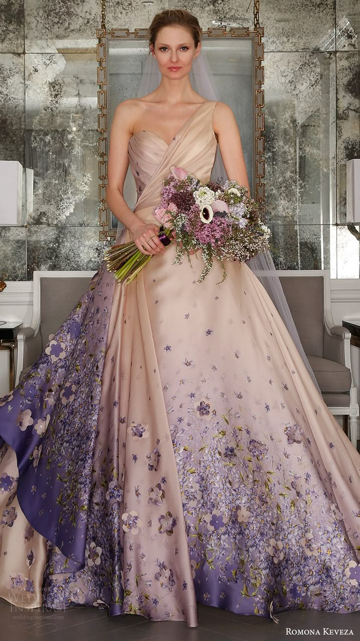 a woman in a wedding dress with flowers on the skirt holding a bridal bouquet