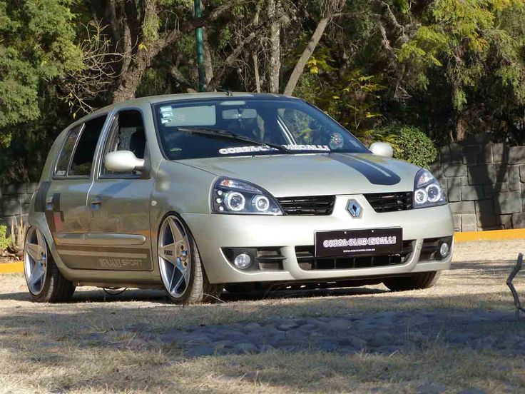 a silver car parked in front of some trees