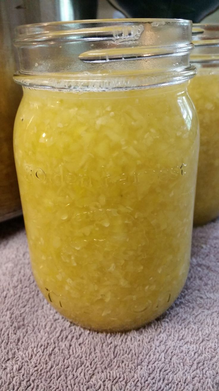 two jars filled with yellow liquid sitting on top of a rug next to an electric pressure cooker