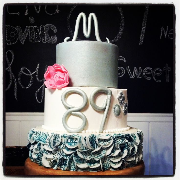 a three tiered cake decorated with ruffles and a pink flower on top