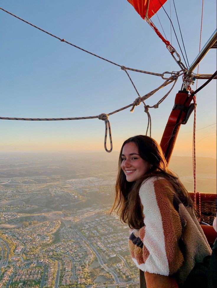 a woman standing on top of a hot air balloon