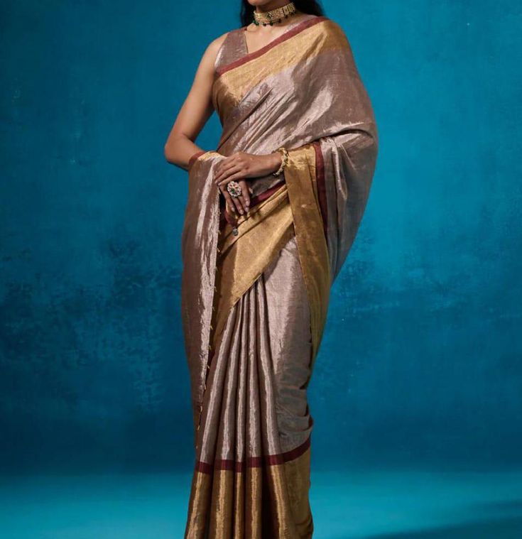 This beautiful Chanderi saree, with a striking combination of golden and silver metallic hues and red stripes, offers a perfect blend of traditional and modern aesthetics. ✨ . The luxurious shine and bold accents make it a statement piece for any occasion. The blouse can be stitched with an additional cost. This saree is 100% original and pure, ensuring authenticity and premium quality.🌟 Don't just wear a saree; own the spotlight with Poonam Sarees! 💫🛍️ #SareeStar #GlamInSilk Fabric: Pure Sil Traditional Silver Pre-draped Saree With Pallu, Silver Saree Blouse Piece In Tissue Silk, Silver Tissue Silk Traditional Pre-draped Saree, Silver Tissue Silk Pre-draped Saree, Designer Silver Tissue Silk Saree, Gold Raw Silk Pre-draped Saree For Transitional Season, Silver Pre-draped Saree With Zari Work For Festive Occasion, Designer Silver Saree With Zari Work, Designer Silver Saree