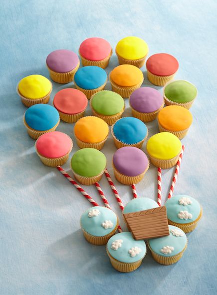 cupcakes with colorful frosting and candy sticks are arranged in the shape of a tree