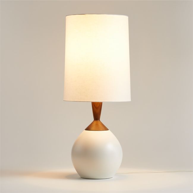 a white table lamp with a wooden base and a light shade on the top of it